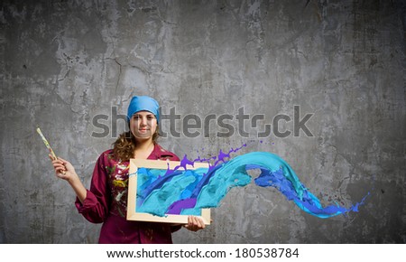 Young woman painter with palette and brush