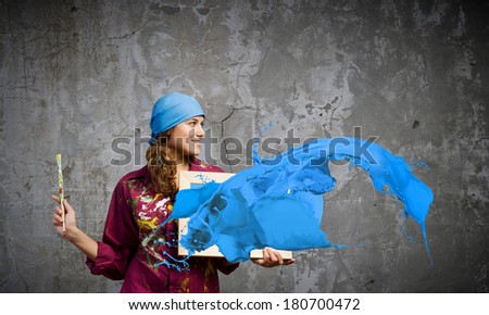 Young woman painter with palette and brush