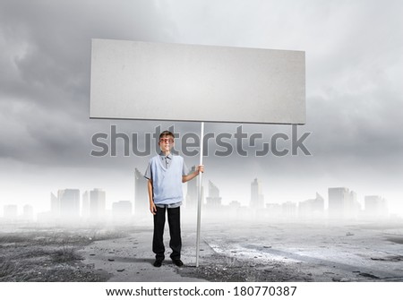 Boy of school age in glasses holding blank white banner