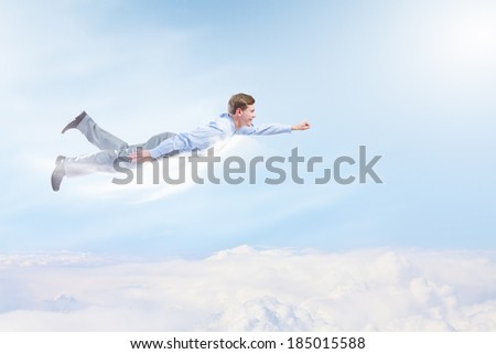 Young businessman superhero flying high in sky