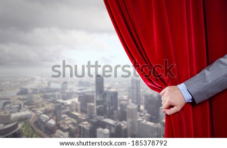 Close up of hand opening red velvet curtain