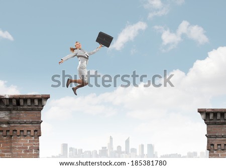 Young businesswoman jumping over gap. Risk concept