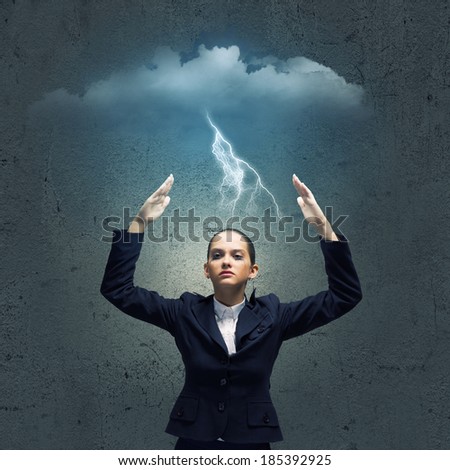 Young crying businesswoman with arms covering head from rain