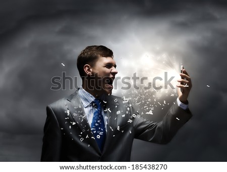 Angry businessman screaming furiously in to mobile phone