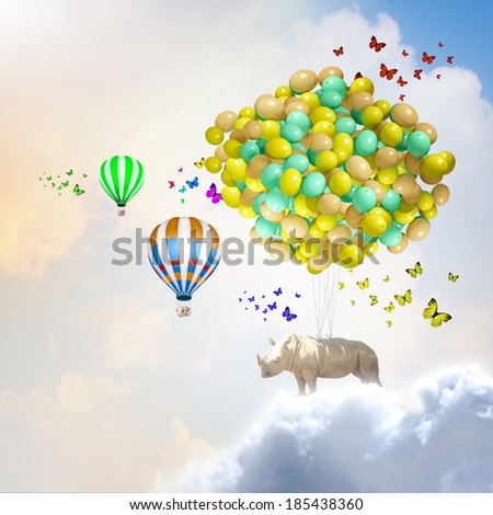 Rhino flying high in sky on bunch of colorful balloons