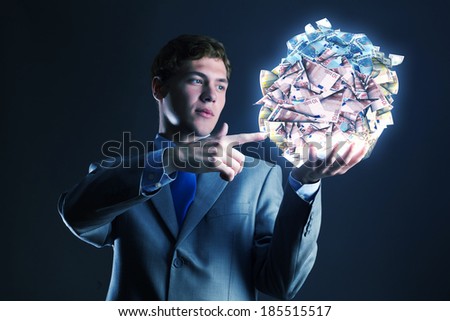 Businessman holding ball of money in hand