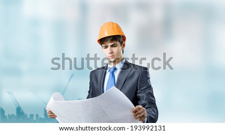 Young man architect looking at construction project