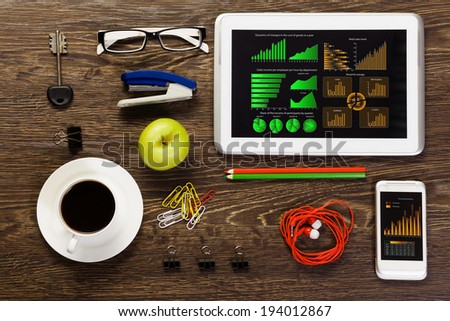 Tablet pc mobile phone and stationary items on wooden table