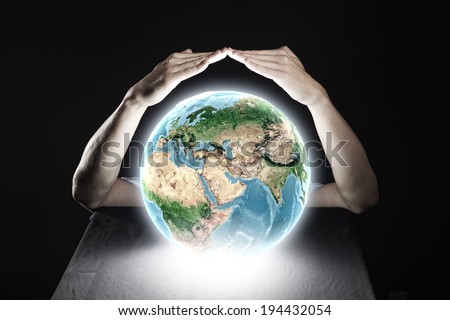 Close up of human hands protecting Earth planet. Elements of this image are furnished by NASA
