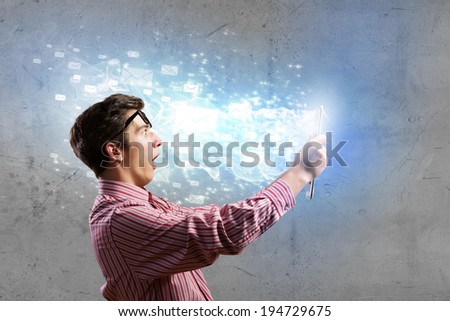 Young man looking shocked in tablet pc