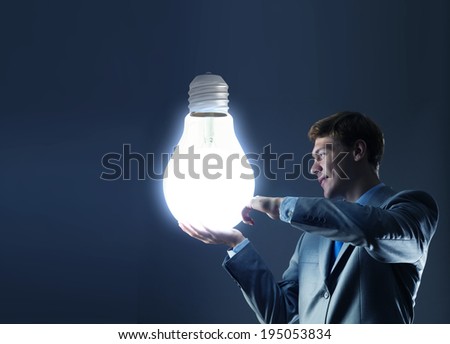 Young man holding light bulb in hand