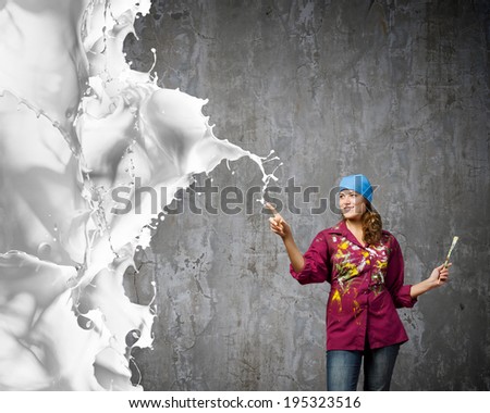 Young woman painter with brush and white splashes above
