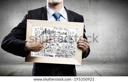 Close up of businessman holding frame with business sketches
