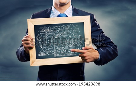 Close up of businessman holding frame with business sketches