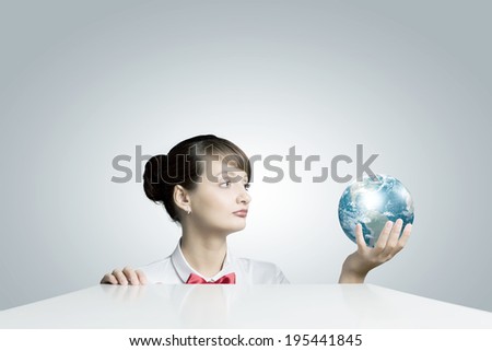 Young smiling woman holding Earth planet in hand. Elements of this image are furnished by NASA