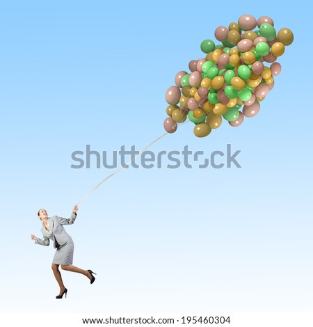 Young businesswoman running with bunch of colorful balloons