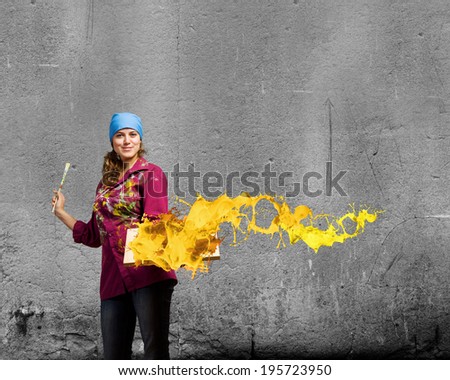 Young woman painter holding frame with colorful splashes