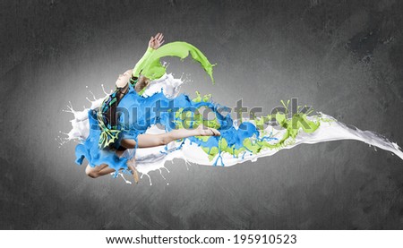 Cute girl gymnast in performance costume jumping high