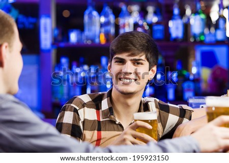 Two young men sitting at bar and talking