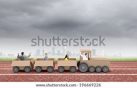 Young business people riding carton train. Teamwork concept