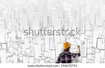 Back view of man engineer drawing buildings