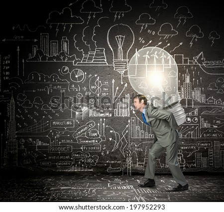 Young businessman carrying light bulb on his back