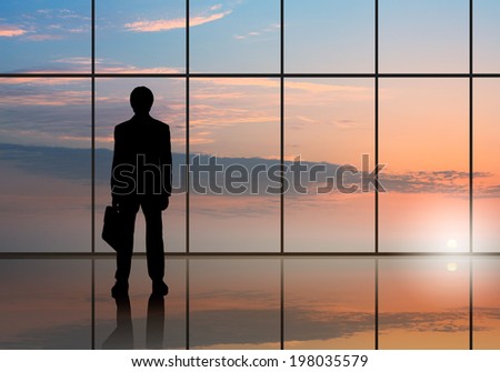 Silhouette of businessman against panoramic office window