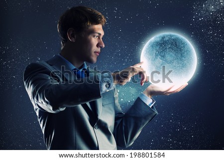 Young businessman holding moon planet in hand