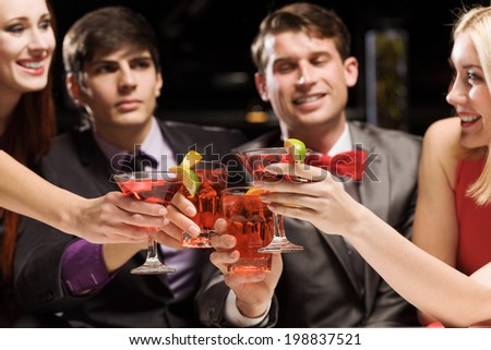 Young attractive people of four having cocktail party
