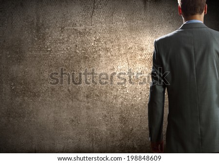 Close up of businessman body in suit against cement background