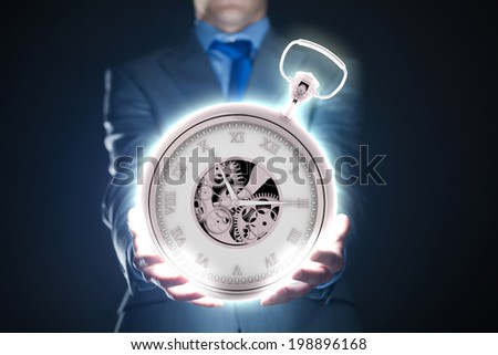 Young businessman holding pocket watch in hand
