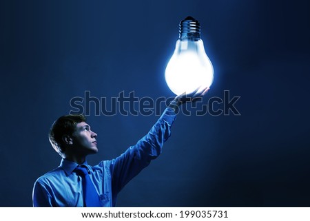Young man holding light bulb in hand