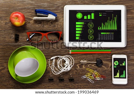 Tablet pc mobile phone and stationary items on wooden table