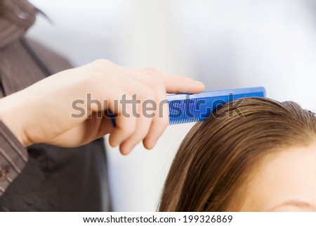 Young woman in chair at barbers and male hairdresser