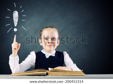 Schoolgirl at lesson with opened book against sketch background