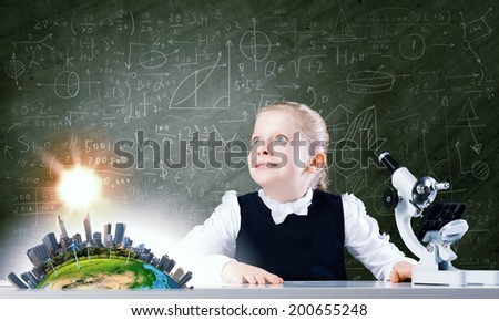 Cute girl with microscope against blackboard. Elements of this image are furnished by NASA
