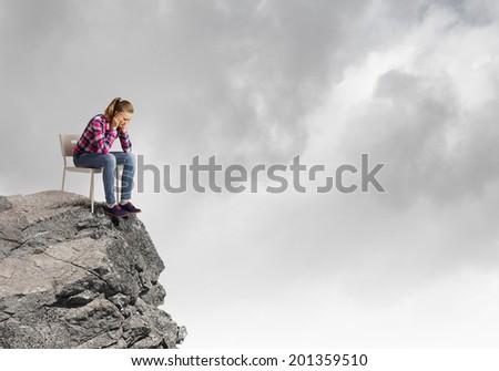 Young woman in casual sitting in chair on top of rock