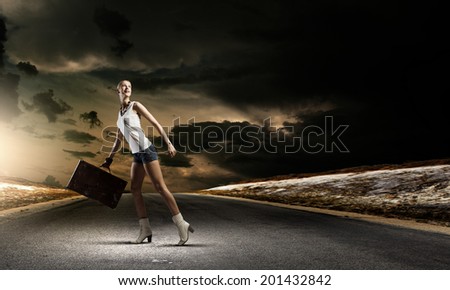 Young woman hiker walking with suitcase in hand