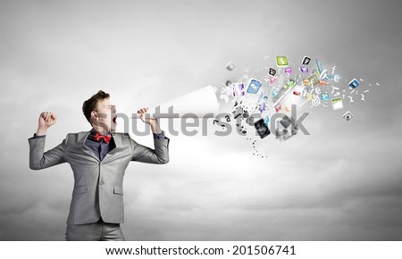 Young businessman speaking in trumpet and colorful icons flying out
