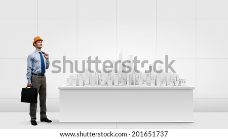 Businessman looking at digital construction project of modern city