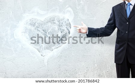 Businessman pointing at stone in shape of heart