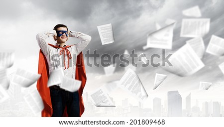 Young man in hero costume closing ears with palms