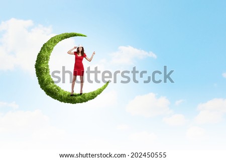 Young woman in red dress walking on moon