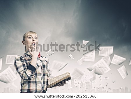 Woman in casual wear holding opened book in hands