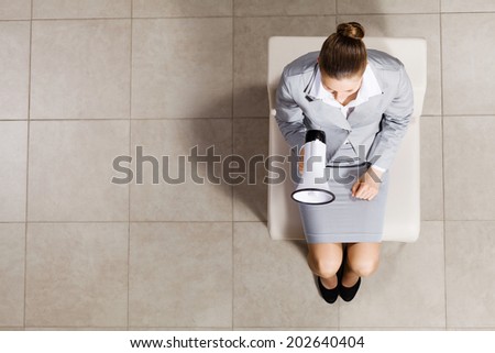Top view of businesswoman sitting on chair with megaphone in hand