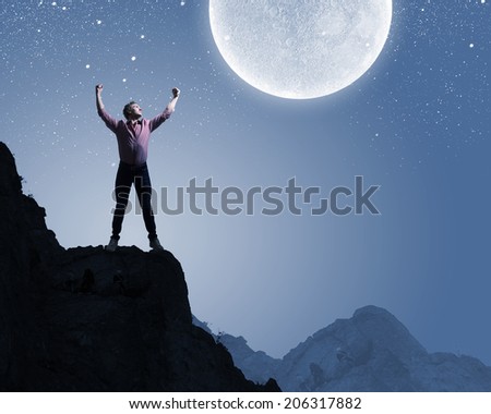 Young man at night with big full moon at background