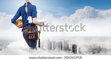 Bottom view of woman engineer with tool belt on waist