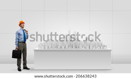 Businessman looking at digital construction project of modern city