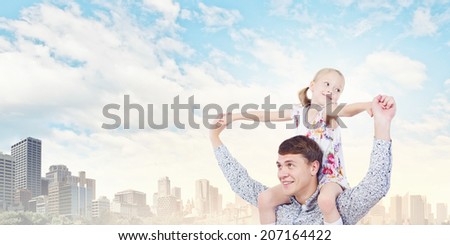 Little daughter sitting on father\'s shoulders. Parenting concept