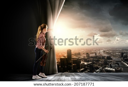 Young girl with violin on stage opening curtain